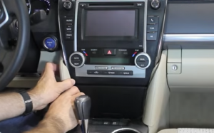 Unclip and remove trim panels from each side of the pocket below the radio or climate control assembly