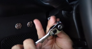 With the trim removed, you are going to remove two bolts on either side of the steering column with a seven millimeter socket set