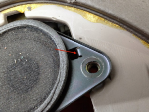 Carefully reconnect the center speaker and reinstall the 2 bolts